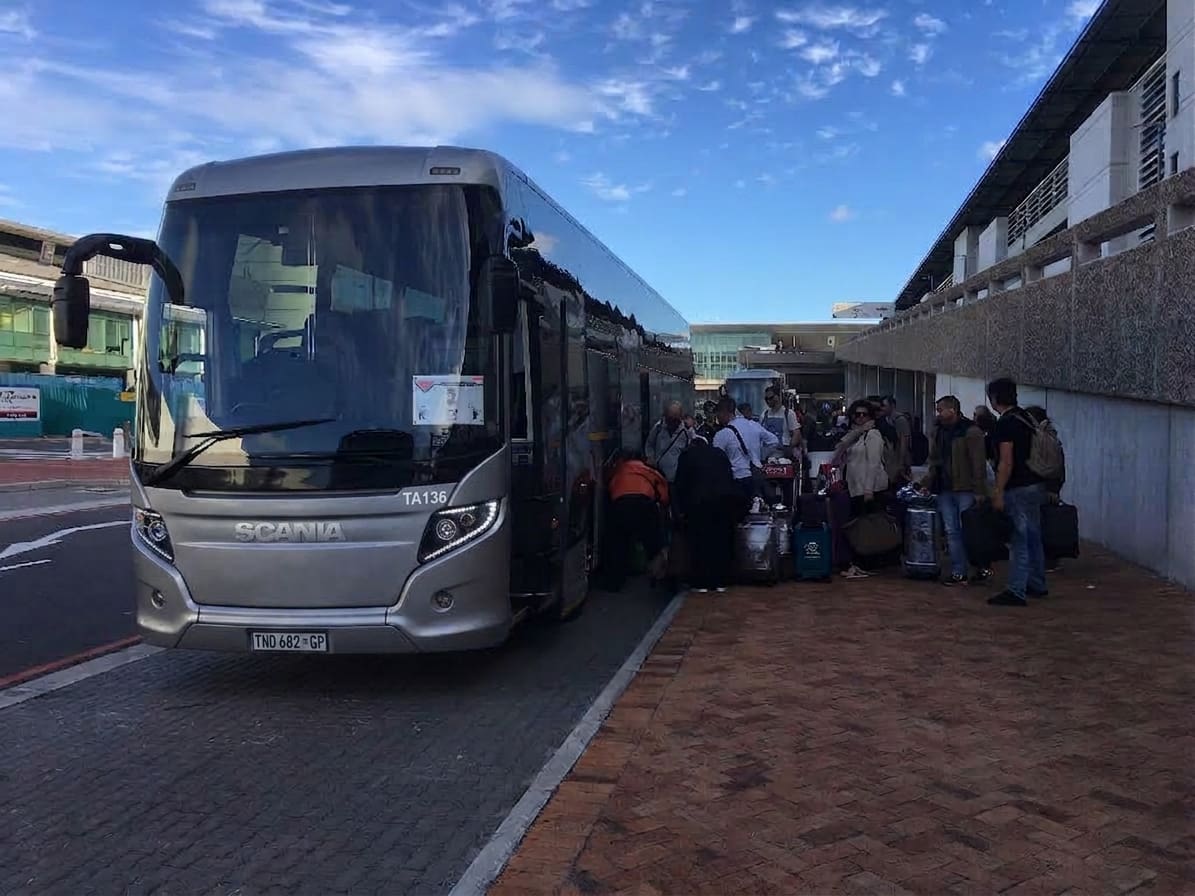 International Group Boarding Luxury Coach at Airport