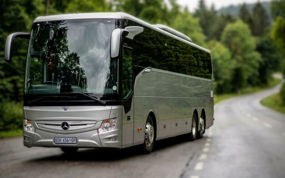 Silver Mercedes Benz 52 seater luxury touring coach parking on side of road