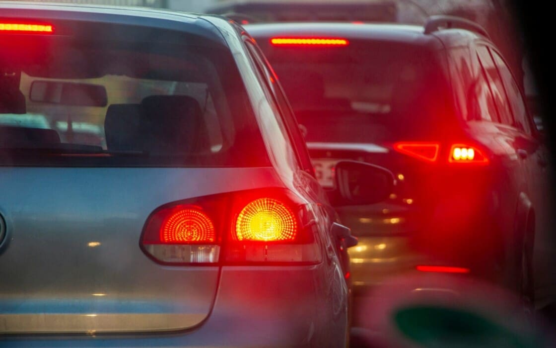 Several separate rental cars driving in a convoy on the highway